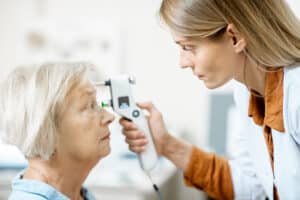Female ophthalmologist measuring the eye pressure with modern to