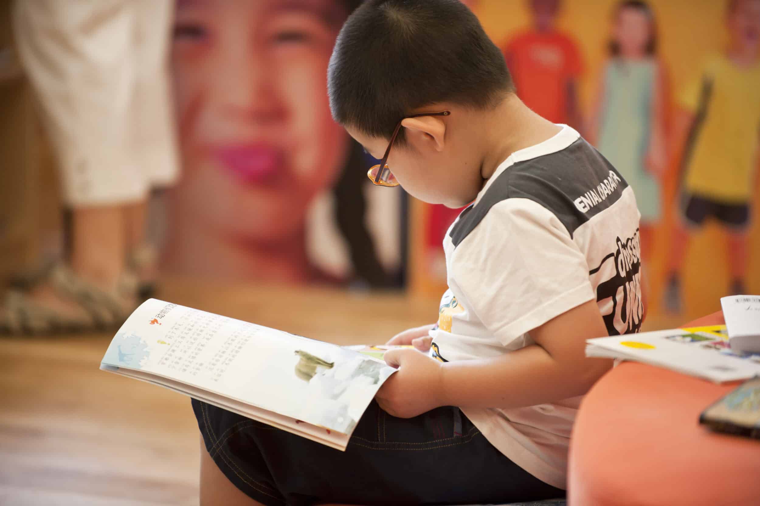 asian boy with glasses read book