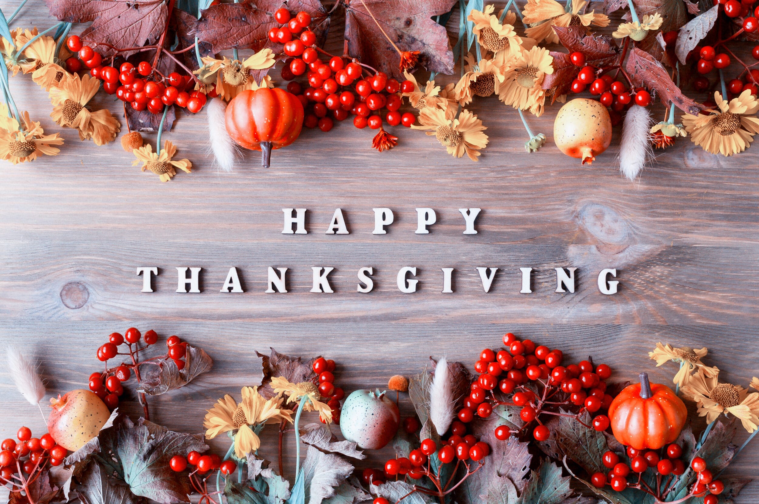Thanksgiving day autumn background with with Happy Thanksgiving letters, seasonal autumn berries, pumpkins, apples