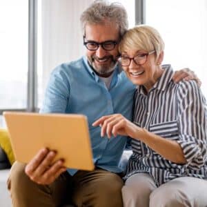 couple smiling at tablet
